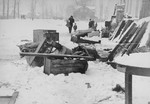 Household furnishings left outside on the street in the Kovno ghetto are covered with snow.