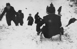 A group of Jewish children go sledding in the Kovno ghetto.
