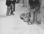 The feet of two men who are standing on a street in the Kovno Ghetto.