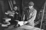 Two youths working in a woodworking shop in the Kovno ghetto.