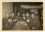 Jewish POWs eat potato pancakes in celebration of Hannuka inside their barracks in POW camp Stalag VIII.