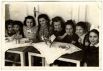 School girls sit by a table to celebrate their teacher's wedding in the Feldafing displaced person's camp.