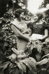 Sisters Magda and Yehudit Scharf pose in the garden of their home.