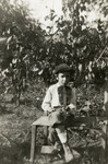 Bondy Scharf sits in the garden of his home holding his violin.