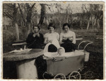 Olga Litman (middle) sits on a park bench and knits while watching her baby Halina sitting in a carriage.