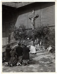 A group of Polish women pray on their knees before a large crucifix hanging outside an old wooden church that had been bombed by German aircraft a day earlier.