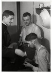 A Polish priest shares cigarettes with German POWs.