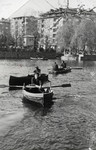 Joseph Dekalo rows a boat on a lake in Sofia wearing his school uniform.
