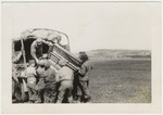 American soldiers load a piano onto a truck.

Original caption:  Loading the Loot-- a "liberated plane"