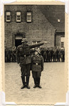 A taller soldier poses next to a smaller one as a joke.