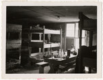 Interior view of the sleeping quarters in a barracks in an unidentified locale.