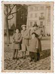 The Chiger family stands on a street in Krakow after the war.
