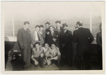 A group of young men pose on board a ship [probably while en route to the United States.
