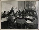 Members of the American Communications Unit responsible for writing newspapers for distribution in Germany meet for an editorial conference in The Habe Circus in Luxembourg.