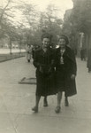 Two Jewish girls in hiding walk down a street in Warsaw.