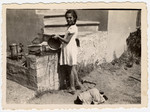 A German-Jewish refugee girl washes dishes outdoors in Shkoset Albania.