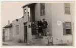 Jewish refugees stand on the steps of their home in Albania.