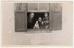 Jewish refugees look through the window of their one room home in Albania.