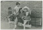 Mara Vishniac sits on a bench surrounded by three younger children.