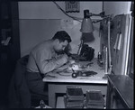 Herbert Lipman repairs cameras for Signal Corps photographers' use.