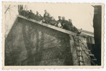 British POWs in Stalag IV A, Elsterhorst pose on the roof of a brick barrack.