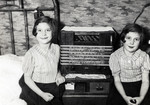Twins Regina and Ruth Anders sit at home next to their radio.