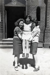Three Jewish girls, one wearing a Star of David, pose outside the school on Grosse Hamburger Strasse.