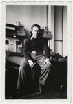 Henri Moskow sits on the edge of his bed.