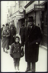 Marcell Jozsef walks down a commercial street in Brasov street with his daughter Agneta.