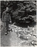 A German boy walks past the corpses of bodies of prisoners from the Woebbelin concentration camp.