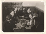 Albert Speer sits around a table with a group of unidentified people.