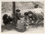 A child who has been selected for deportation, bids farewell to his family through the wire fence of the central prison, during the "Gehsperre" action in the Lodz ghetto.