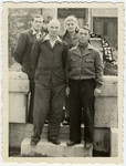 Four cousins pose in front of a memorial at the Leipheim displaced persons camp.