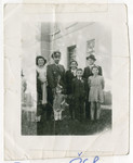 Surviving members of the Smilovic family pose outside a building in Doksy shortly after the end of World War II.