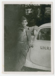 Joint Distribution Committee worker Robert Wilonsky leans against an UNRRA automobile.