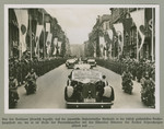 A motorcade proceeds down a Berlin street lined with Japanese and Nazi flags.