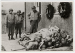 American soldiers view the bodies of emaciated Buchenwald prisoners stacked up next to the crematoria.