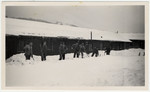 Jewish internees shovel snow in front of the barracks of an unidentified Swiss labor camp.