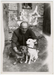 Richard Stock poses with two dogs, Bobby and Jimmy,  outside a building in Shanghai.