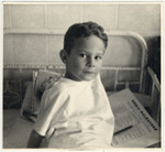 Robert Wagemann, a physically disabled Jehovah's Witness child, sits on his hospital bed.