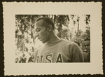 A profile view of Jesse Owens wearing his USA Olympic tracksuit.