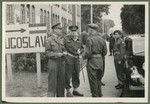 British soldiers stand outside a building with a sign indicating where Yugoslav nationals should gather.