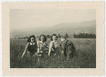Four young people who had come to Switzerland on the Kasztner transport pose in a grassy field.