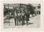 Four young people pose together on a street in Montreux, Switzerland after arriving on the Kasztner transport.