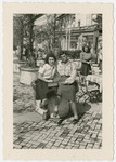 Two women who came to Switzerland on the Kasztner tranport pose together at an outdoor cafe.