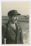 A young Jewish man stands in a field.