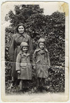 Shanke Minuskin stands outside in the Zeilsheim displaced persons' camp with her two sons, Kalman and Henik.