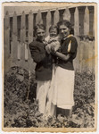 Shlamke and Shanke Minuskin pose with their baby son, Henikel, in the garden of their home.