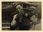 Close-up of DP father holding his young child at a train station.