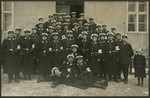 German medical officers pose before an unidentified building, Walter Lande (in glasses) is pictured second from the right in the third row from the top.
